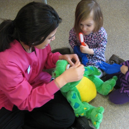 Adult and young child playing with colorful toy blocks together indoors.