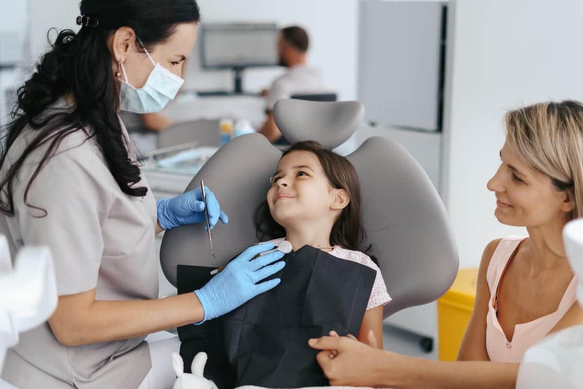 Pediatric dental patient receiving white filling treatment from dentist in Greensboro dental office.